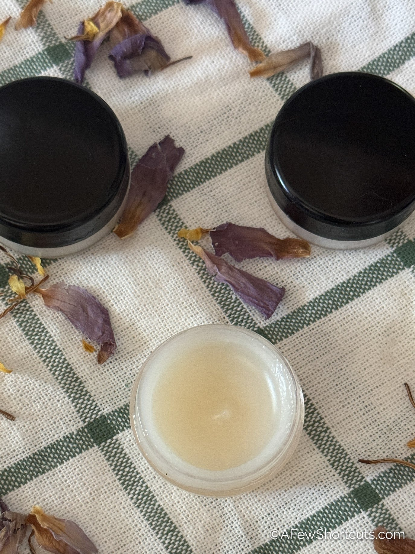 Homemade Lip Balm with lard on white and green hand towel with flowers